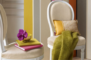 Deux chaises médaillons recouvertes de lin brut devant un paravent tendu d'un tissu rayer montrent l'atmosphère d'un intérieur de particulier